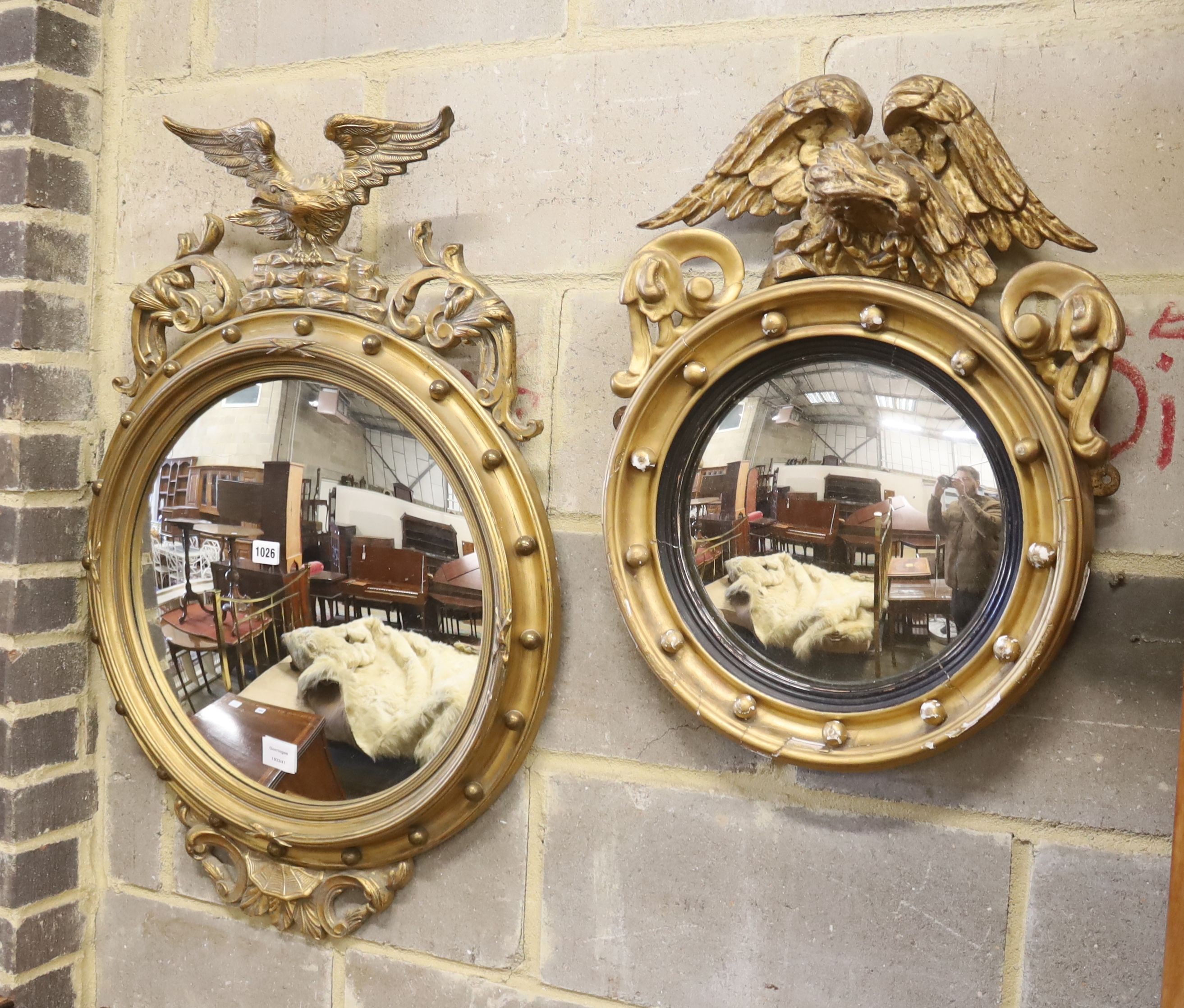 A small Regency gilt convex wall mirror, with eagle leaf carved surmount and ball surround and another convex mirror, larger width 58cm, height 86cm